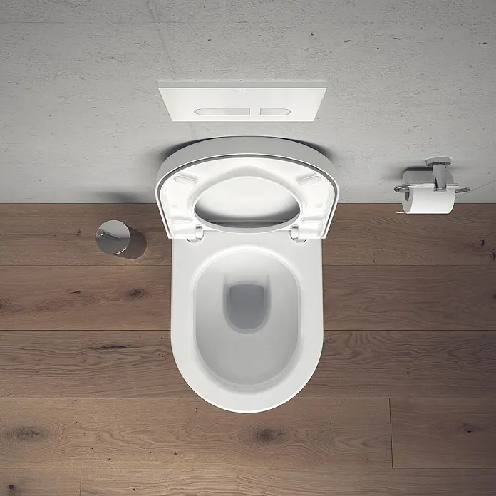 Duravit Starck 3 Wand-WC-Set - Mit Spülrand, Ohne Spezialglasur, Spülform: Tief, WC Abgang: Waagerecht, Sichtbarkeit Befestigung: Sichtbar - Draufsicht auf eine moderne, weiße Toilette mit offenem Deckel, die an einer Betonwand montiert ist.