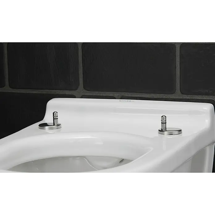 Duravit Starck 3 Wand-WC - Spülrandlos, Mit antibakterieller Glasur, Spülform: Tief, WC Abgang: Waagerecht, Weiß - Nahaufnahme einer weißen Duravit Toilette mit silbernen Beschlägen vor einer dunklen Steinwand.
