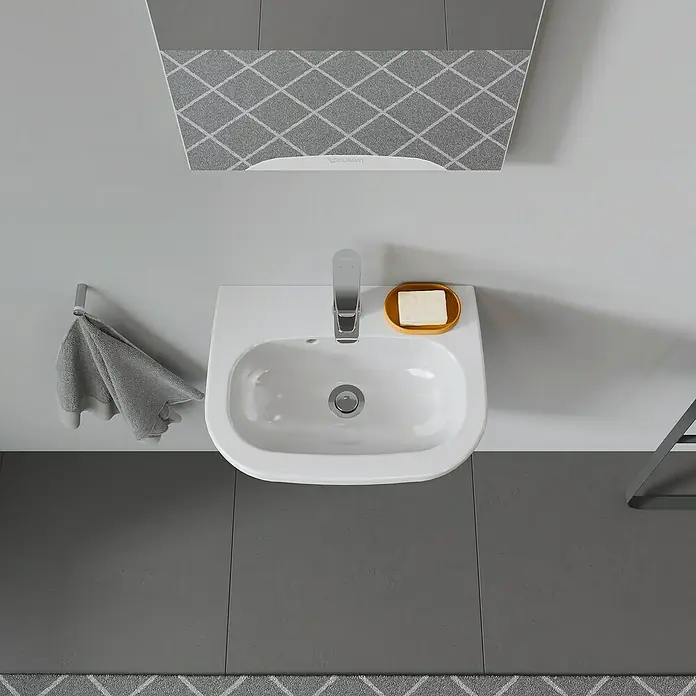 Duravit D-Code Waschbecken - 45 x 34 cm, Ohne Spezialglasur, Hahnloch: Mitte, Mit Überlauf, Weiß - Eine elegante, moderne Waschbeckenarmatur mit Seifenschale und Handtuchhalter in einem stilvollen Badezimmer.
