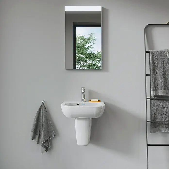 Duravit D-Code Waschbecken - 45 x 34 cm, Ohne Spezialglasur, Hahnloch: Mitte, Mit Überlauf, Weiß - Nahaufnahme eines Duravit-Waschbeckens mit Armatur, Spiegel und Handtuchhalter in einem stilvollen Badezimmer.