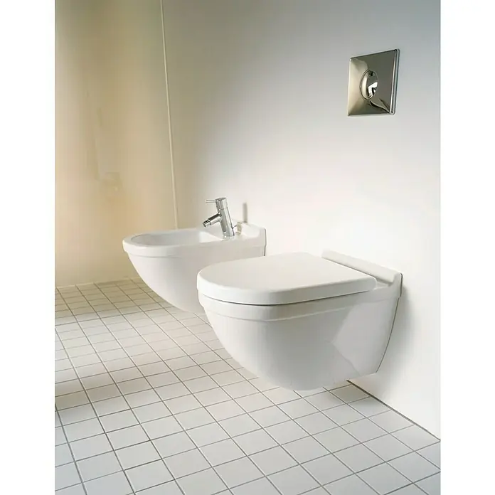 Duravit Starck 3 Wand-WC - Spülrandlos, Mit antibakterieller Glasur, Spülform: Tief, WC Abgang: Waagerecht, Weiß - Hänge-WC und Bidet in einem modernen Badezimmer mit weißen Fliesen und minimalistischem Design, das die sanitären Anlagen hervorhebt.