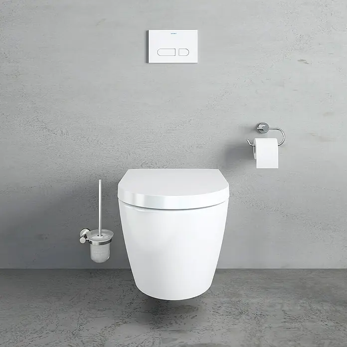 Duravit ME by Starck Wand-WC-Set Typ 1 - Spülrandlos, Ohne Spezialglasur, Spülform: Tief, WC Abgang: Waagerecht, Weiß - Das Bild zeigt eine moderne, wandhängende Toilette in einem minimalistischen Badezimmer mit Betätigungsplatte und Toilettenpapierhalter.