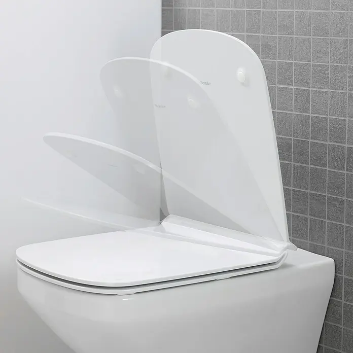 Duravit DuraStyle Wand-WC-Set - Spülrandlos, Ohne Spezialglasur, Spülform: Tief, WC Abgang: Waagerecht, Weiß - Nahaufnahme einer weißen Toilette mit einem sich öffnenden und schließenden Toilettendeckel, der die sanfte Bewegung hervorhebt.