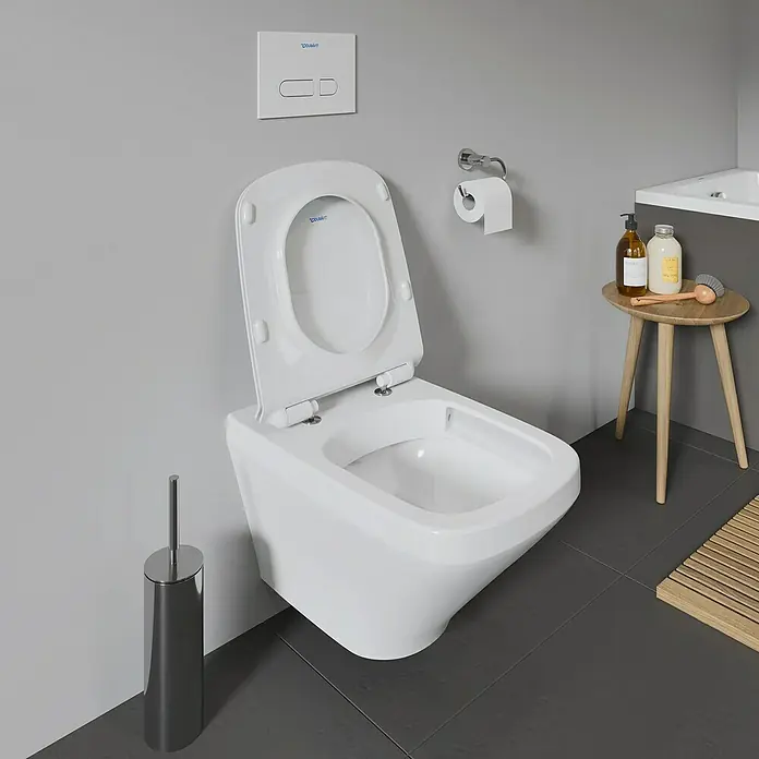 Duravit DuraStyle Wand-WC - Spülrandlos, Ohne Spezialglasur, Spülform: Tief, Sichtbarkeit Befestigung: Verdeckt, Weiß - Nahaufnahme einer Duravit Wandtoilette mit offenem Deckel in einem modernen Badezimmer mit grauen Fliesen und Wand.