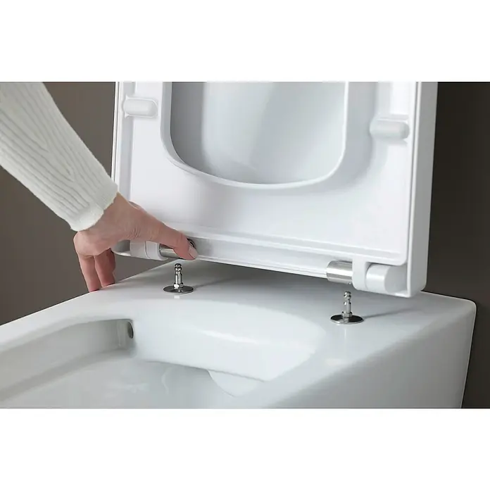 Duravit ME by Starck Wand-WC-Set Typ 1 - Spülrandlos, Ohne Spezialglasur, Spülform: Tief, WC Abgang: Waagerecht, Weiß - Nahaufnahme eines weißen WC-Sitzes, der von einer Hand bedient wird, um die einfache Montage und Demontage zu demonstrieren.