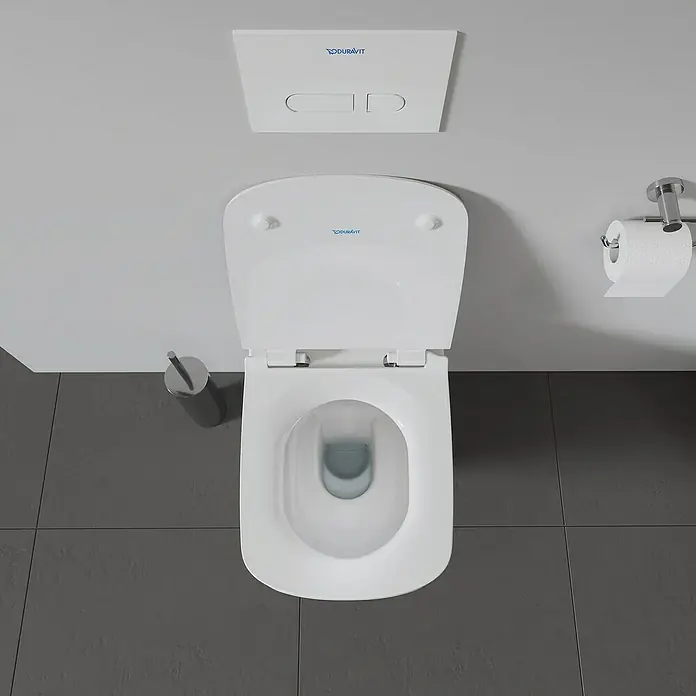 Duravit DuraStyle Wand-WC - Spülrandlos, Ohne Spezialglasur, Spülform: Tief, Sichtbarkeit Befestigung: Verdeckt, Weiß - Ein Duravit Wand-WC mit offenem Deckel und einer Toilettenbürste daneben, vor einer grauen Wand.