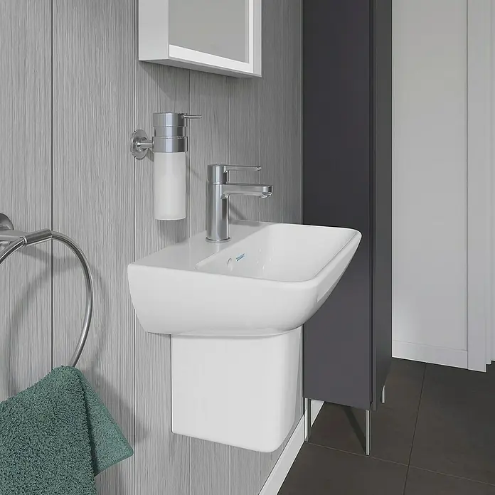 Duravit ME by Starck Waschbecken - 45 x 32 cm, Ohne Spezialglasur, Hahnloch: Mitte, Mit Überlauf, Weiß - Nahaufnahme eines modernen, an der Wand montierten Waschbeckens mit Armatur, Seifenspender und Handtuchring im Badezimmer.