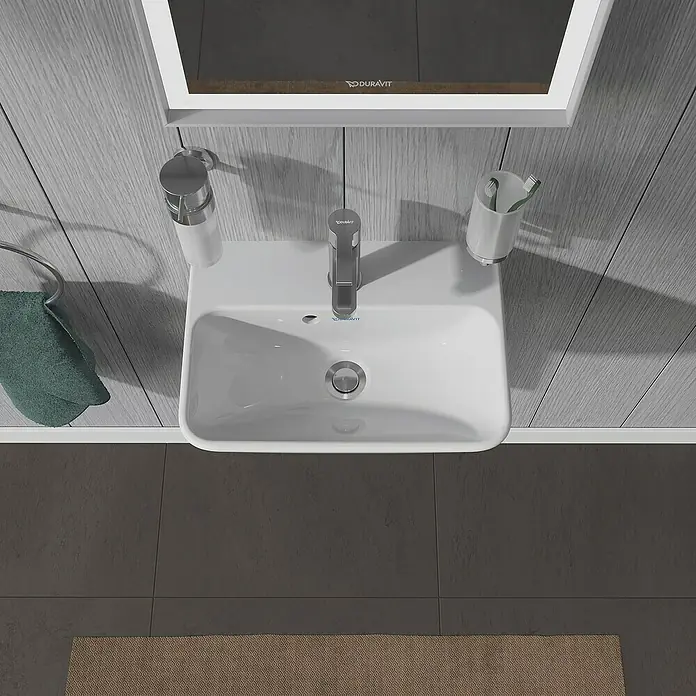 Duravit ME by Starck Waschbecken - 45 x 32 cm, Ohne Spezialglasur, Hahnloch: Mitte, Mit Überlauf, Weiß - Draufsicht auf ein weißes Duravit-Waschbecken mit Armatur, Seifenspender und Zahnputzbecher im Badezimmer.