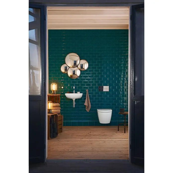 Duravit ME by Starck Waschbecken - 45 x 32 cm, Ohne Spezialglasur, Hahnloch: Mitte, Mit Überlauf, Weiß - Stilvolles Badezimmer mit Wand-WC, Waschbecken und Spiegeln vor einer smaragdgrünen Kachelwand. Holzfußboden rundet das elegante Design ab.