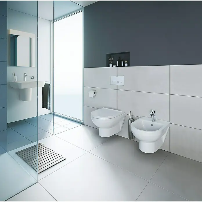 Duravit DuraStyle Wand-WC-Set Basic - Spülrandlos, Ohne Spezialglasur, Spülform: Tief, WC Abgang: Waagerecht, Weiß - Das Bild zeigt ein modernes Badezimmer mit einer wandhängenden Toilette und einem Bidet, die durch ihr schlichtes Design Eleganz ausstrahlen.