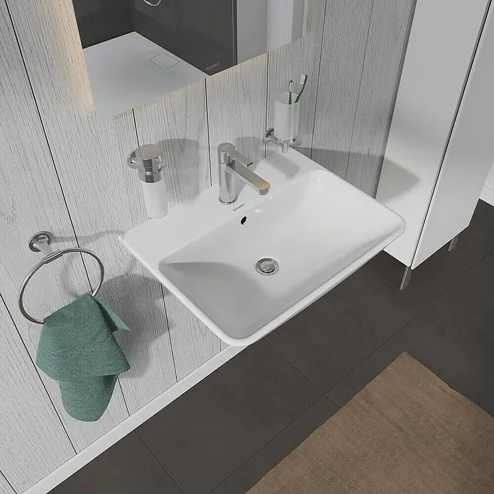 Duravit ME by Starck Waschtisch Typ 2 - 60 x 46 cm, Ohne Spezialglasur, Hahnloch: Mitte, Mit Überlauf, Weiß - Das Bild zeigt ein modernes Badezimmerwaschbecken mit Armatur, Seifenspender und Handtuchring, das eine stilvolle Badezimmerausstattung präsentiert.