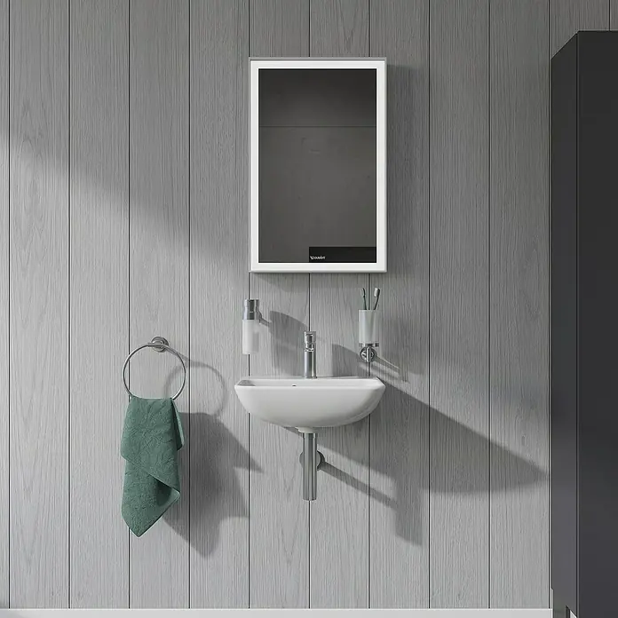 Duravit ME by Starck Waschbecken - 45 x 32 cm, Ohne Spezialglasur, Hahnloch: Mitte, Mit Überlauf, Weiß - Das Foto zeigt ein modernes Badezimmer-Waschbecken mit Spiegel, Handtuchhalter und minimalistischem Design vor einer grauen Holzwand.