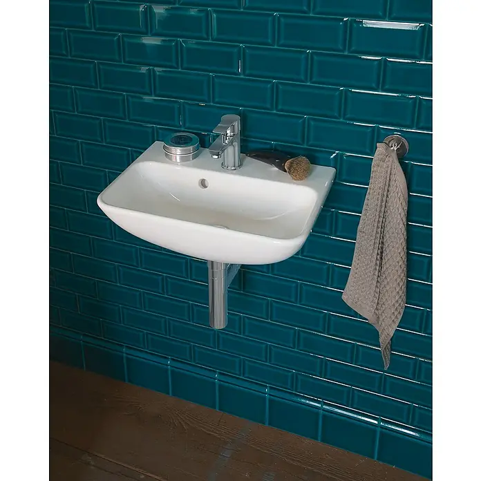 Duravit ME by Starck Waschbecken - 45 x 32 cm, Ohne Spezialglasur, Hahnloch: Mitte, Mit Überlauf, Weiß - Dieses Bild zeigt ein modernes Waschbecken mit Armatur an einer blaugrünen Wand. Ein Handtuch hängt daneben.