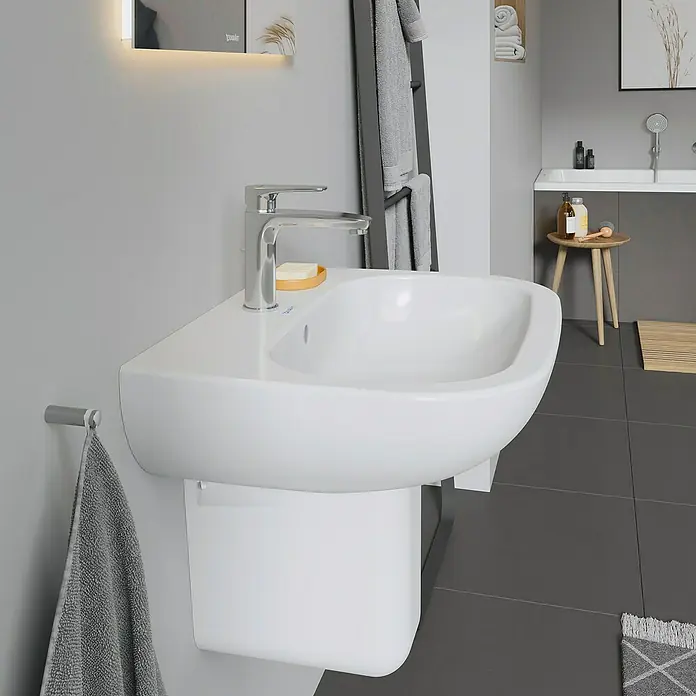 Duravit D-Code Waschtisch - 60 x 46 cm, Ohne Spezialglasur, Hahnloch: Mitte, Mit Überlauf, Weiß - Nahaufnahme eines modernen, weißen Waschbeckens mit Chromarmatur in einem stilvollen Badezimmer, das ein elegantes und minimalistisches Design zeigt.
