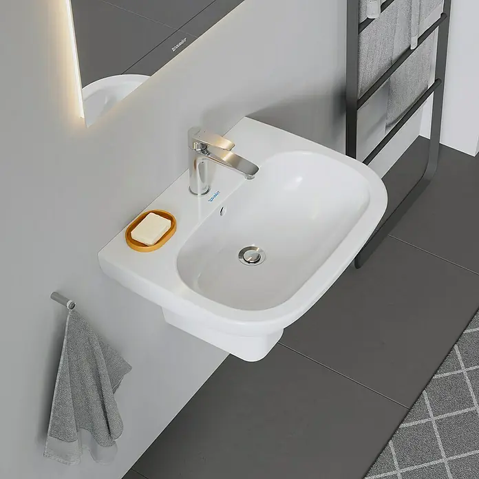 Duravit D-Code Waschtisch - 60 x 46 cm, Ohne Spezialglasur, Hahnloch: Mitte, Mit Überlauf, Weiß - Hochwinkelaufnahme eines Duravit-Waschbeckens mit Seife und Handtuch.