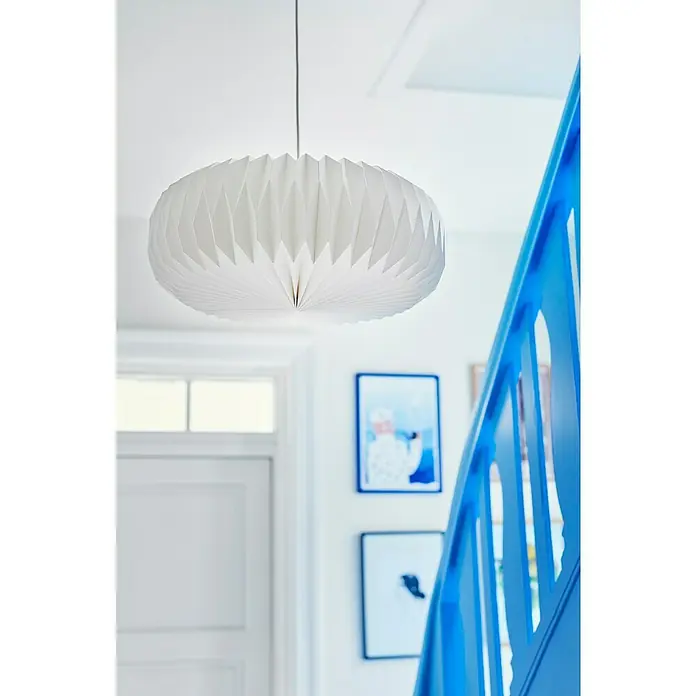 Nordlux Lampenschirm BELLOY - L x B x H: 45 x 45 x 18 cm, Weiß, 45 cm - Eine moderne, weiße Papierpendelleuchte hängt in einem hellen Treppenhaus mit blauem Geländer und Bildern an der Wand.