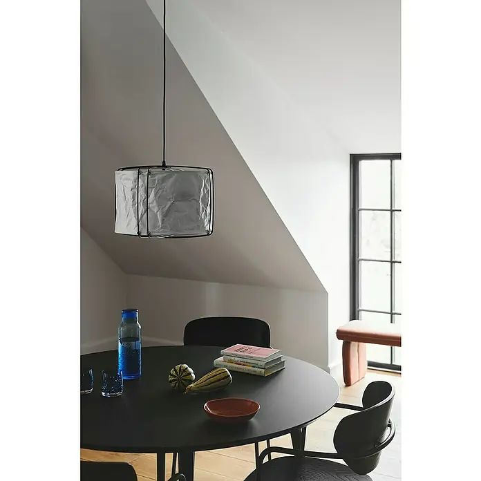 Nordlux Pendelleuchte rund CARDINE - 60 W, Ø x H: 35 x 28,5 cm, Weiß, Schwarz, E27 - Eine moderne Pendelleuchte mit einem Lampenschirm aus zerknittertem Papier hängt über einem Esstisch mit diversen Gegenständen.