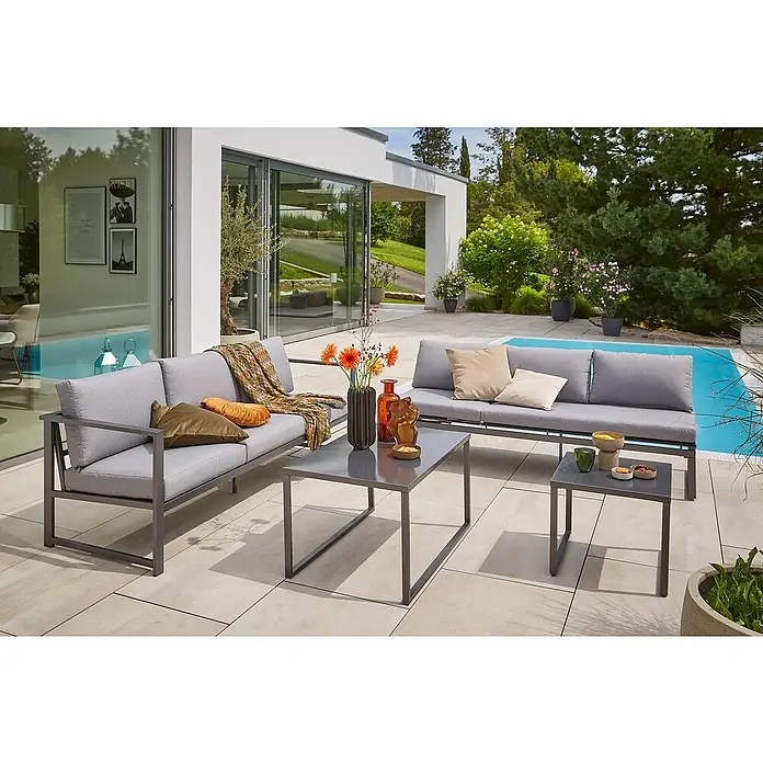Sunfun Maja Slim Garten-Couchtisch - L x B x H: 90 x 60 x 50 cm, Anthrazit - Moderne Gartenmöbel-Gruppe mit grauem Sofa, Sesseln und Tischen auf einer Terrasse mit Poolblick.