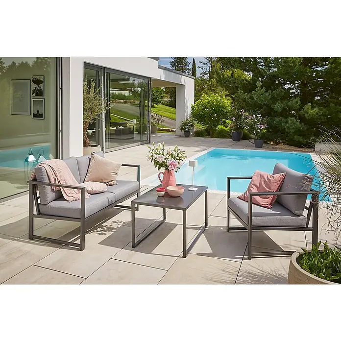 Sunfun Maja Slim Loungesessel - B x T x H: 75 x 72 x 65 cm, Aluminium, Anthrazit - Gartenmöbel-Set mit einem grauen Sofa, einem Sessel und einem Tisch mit Blumen und Dekorationen, ideal für entspannte Stunden im Freien.