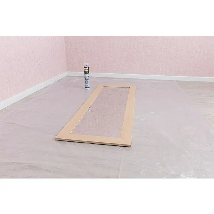 Mako Abdeckfolie Basic - L x B: 2,5 x 4 m, 10 m² - Auf dem Boden liegt eine Holztür mit Glas und eine Dose weißer Farbe, bereit zum Lackieren. Die Szene zeigt Vorbereitungen für ein DIY-Projekt.
