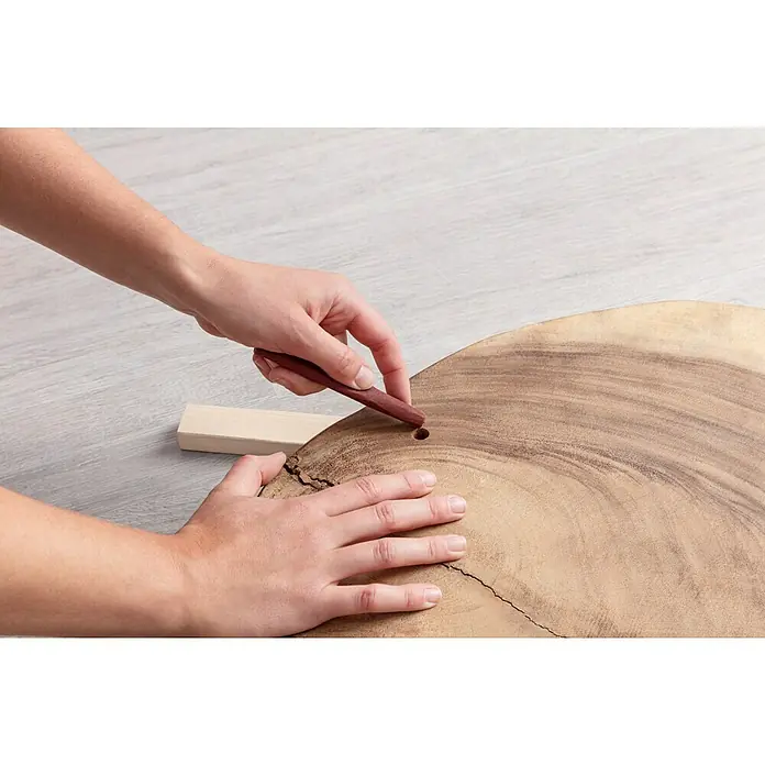 Craftomat Papel de lija - An x L: 93 mm x 5 m, Grano: 120 mm - Primer plano de una persona lijando una tabla de madera con papel de lija para alisarla. El proyecto destaca la veta natural de la madera.