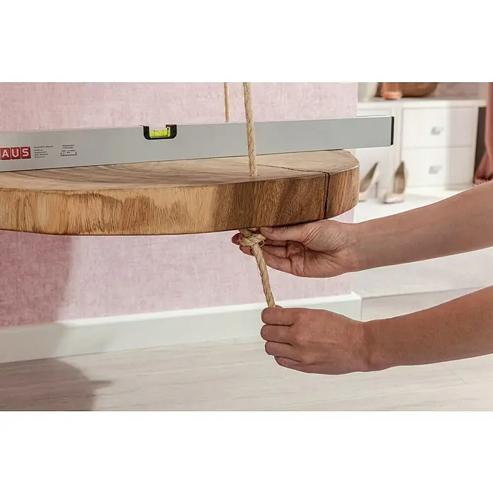 BAUHAUS Nivel de burbuja - Largo: 80 cm, Aluminio, Gris - Primer plano de un estante de madera rústico colgando de un columpio de cuerda que está siendo equilibrado con un nivel de burbuja.
