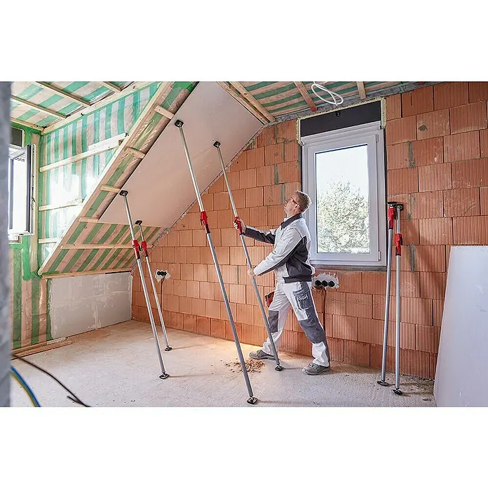 Bessey Montagestütze STE 300Verstellbar: 170 cm - 300 cm - Ein Bauarbeiter verwendet eine Trockenbau-Montagestütze, um eine Deckenplatte während der Installation zu halten. Das Werkzeug erleichtert die Arbeit.