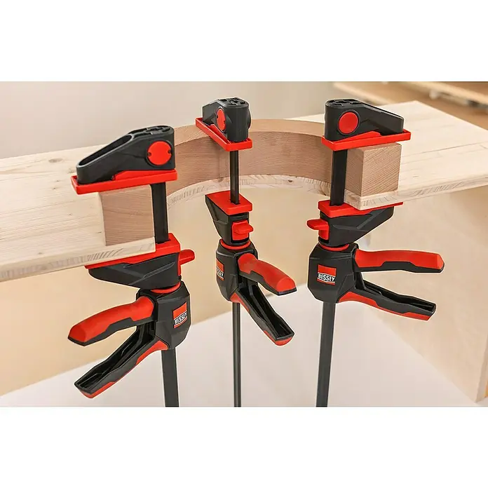 Bessey Einhandzwinge EZ 360-60Spannweite: 600 mm, Ausladung: 80 mm - Drei BESSEY Einhandzwingen im Einsatz, um Holzstücke zusammenzuhalten, ideal für präzise Holzbearbeitung und Montagearbeiten in der Werkstatt.