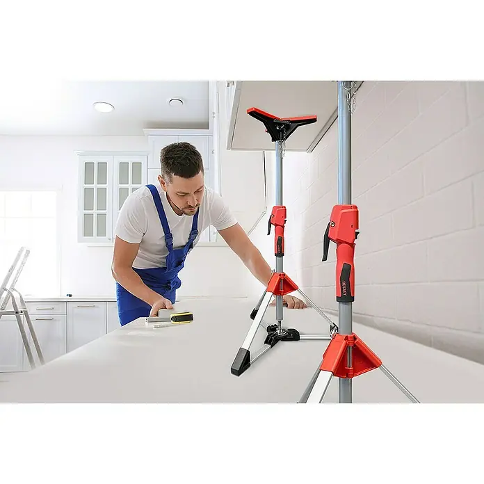 Bessey Montagestütze STE 90 - Verstellbereich: 57,5 cm - 91 cm - Ein Handwerker mit BESSEY Stützen beim Anbringen eines Schranks. Die BESSEY Stützen sind rot und silberfarben und haben eine dreibeinige Basis.