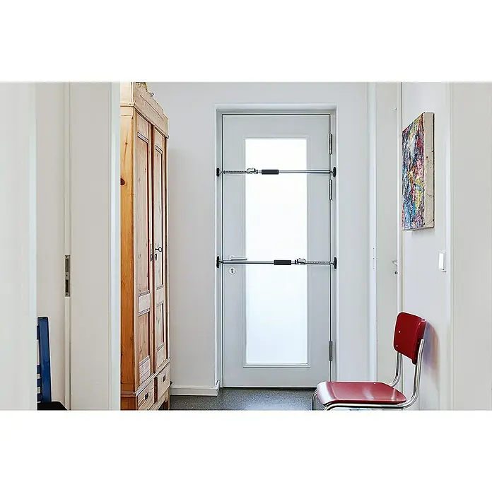 Bessey Montagestütze ST 250 - Verstellbereich: 145 cm - 250 cm - Bild eines Türgitters, das an einer weißen Tür angebracht ist, mit einem Holzschrank und einem roten Stuhl im Flur.