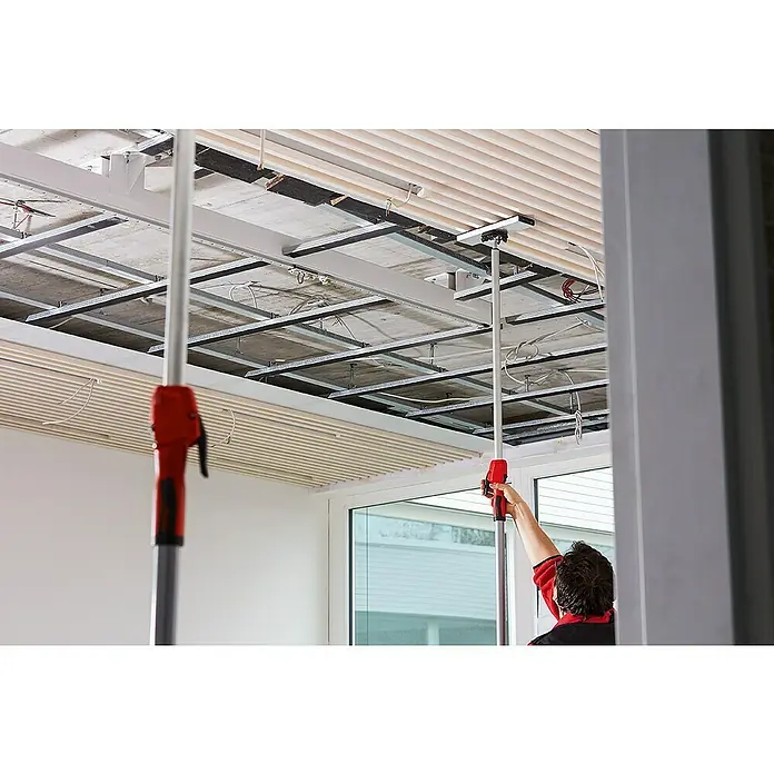 Bessey Deckenstütze STE-SP35 - Silber - Ein Mann benutzt ein Werkzeug, um die Decke zu befestigen. Das Werkzeug ist lang und hat einen roten Griff.