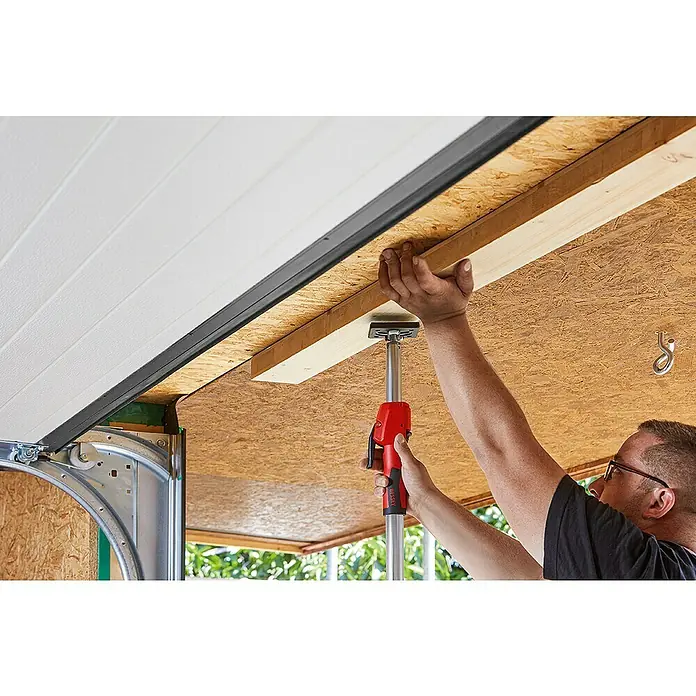 Bessey Montagestütze STE 250 - Verstellbereich: 145 cm - 250 cm - Ein Handwerker verwendet eine BESSEY Stütze, um ein Holzbrett an einer Decke zu befestigen, während er an einem Bauprojekt arbeitet.