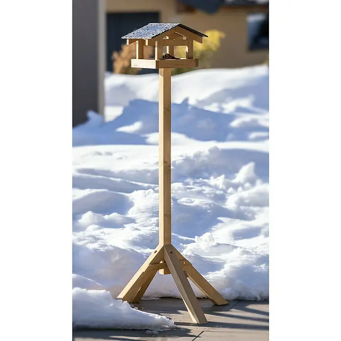Windhager Vogelhausständer Vierbein124 cm, Natur - Ein hölzernes Vogelhaus mit einem Ständer steht im Schnee, ideal für die Vogelfütterung im Winter und eine dekorative Ergänzung für jeden Garten.