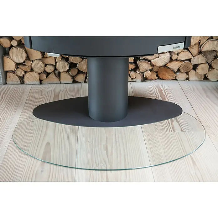 Aduro Glasbodenplatte - 114,8 x 68,3 cm, Rund - Nahaufnahme eines modernen Kaminofens mit Holzscheitlagerung und einer runden Glasbodenplatte.