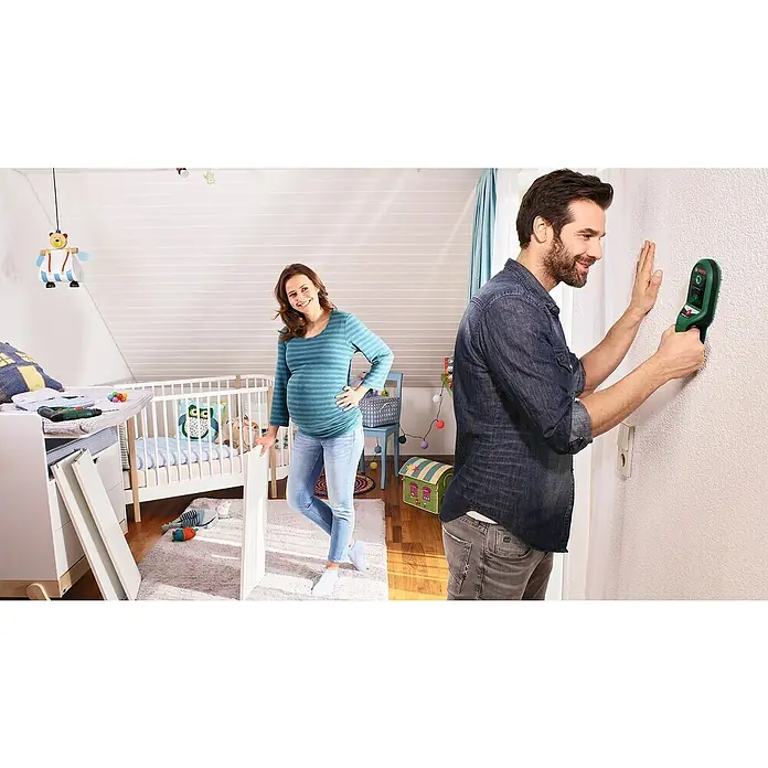 Bosch Ortungsgerät UniversalDetect - Geeignet für: Aufspüren von spannungsführenden Leitungen, Holz und Metall, Erfassungstiefe: Max. 50 mm stromführende Leitung - Ein Mann benutzt einen Bosch-Detektor an einer Wand, während eine schwangere Frau ein Kinderbett zusammenbaut.