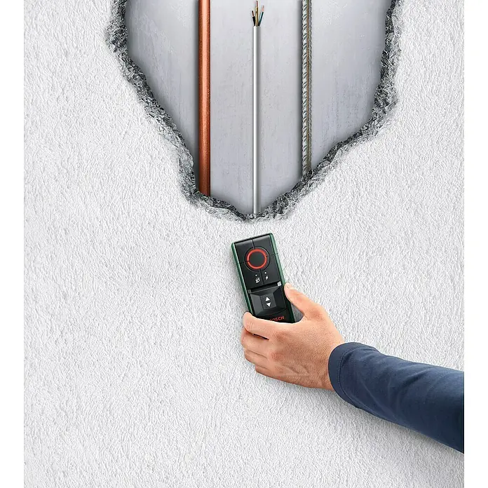 Bosch Ortungsgerät Truvo II - Geeignet für: Aufspüren von spannungsführenden Leitungen und Metall, Erfassungstiefe: Max. 70 mm Eisenmetalle - Abbildung eines Bosch-Ortungsgeräts, das vor einer beschädigten Wand verwendet wird, um verborgene Leitungen und Rohre zu lokalisieren.