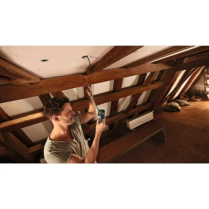 Bosch Universal Endoskopkamera UniversalInspect - Länge Schwanenhals: 95 cm, 11 -tlg. - Ein Mann benutzt einen Bosch Inspektionskamera zur Überprüfung eines Deckenkabels. Das Gerät ist grün und hat einen Bildschirm.