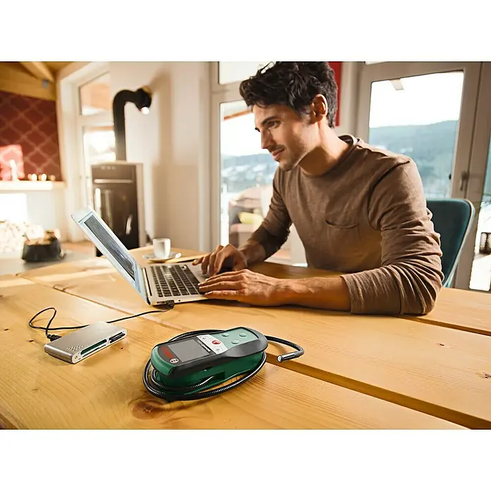 Bosch Universal Endoskopkamera UniversalInspect - Länge Schwanenhals: 95 cm, 11 -tlg. - Der Mann arbeitet mit einem Laptop, an dem ein externes Lesegerät und ein Endoskop der Marke Bosch angeschlossen sind.