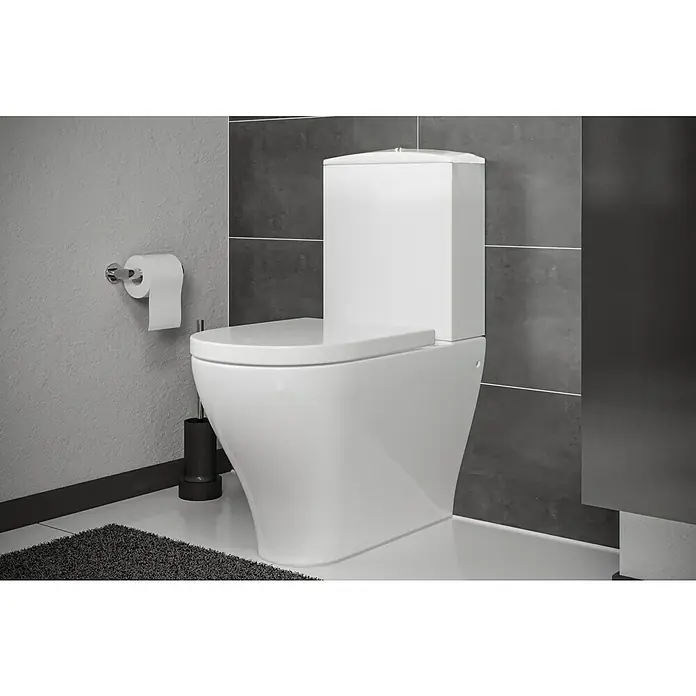 Camargue San Francisco Spülkasten - Ohne Spezialglasur, Keramik, Weiß - Nahaufnahme einer modernen, weißen Toilette mit Spülkasten in einem Badezimmer mit grauen Fliesen und minimalistischem Design.