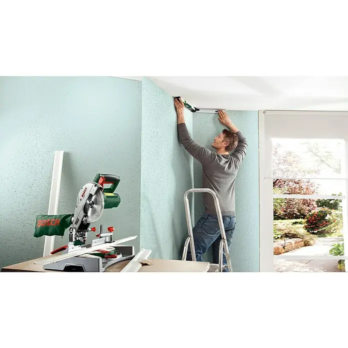 Bosch Universal Digitaler Winkelmesser UniversalAngle - Messbereich: 0 - 220 °, Anzahl Libellen: 2 Stk. - Mann befestigt eine Zierleiste mit einem Bosch Kapp- und Gehrungssäge GCM 8 SJL.