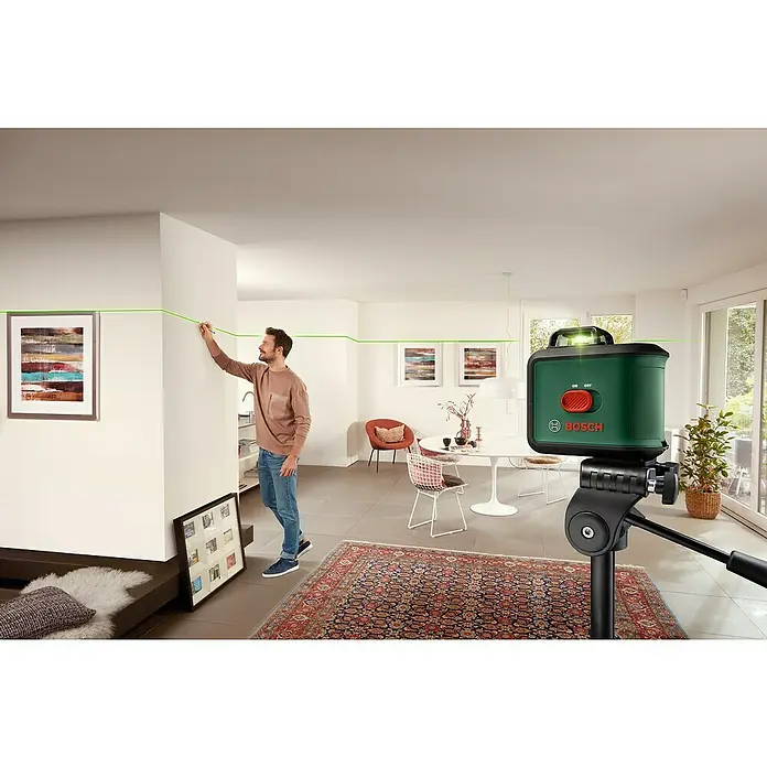 Bosch Kreuzlinienlaser UniversalLevel 360 Set - Max. Arbeitsbereich: 12 m, 7 -tlg. - Ein Mann benutzt einen Bosch Linienlaser, um eine gerade Linie an einer Wand zu markieren, ideal für präzise Ausrichtung.