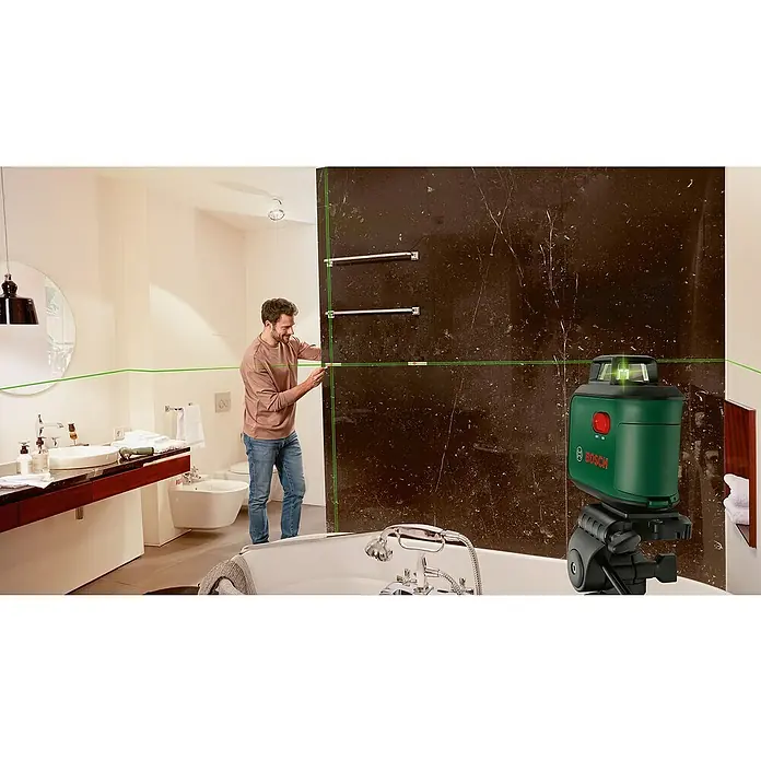 Bosch Kreuzlinienlaser AdvancedLevel 360Max. Arbeitsbereich: 12 m, 7 -tlg. - Bild eines grünen Bosch-Laser-Nivelliergeräts, das in einem Badezimmer auf einem Stativ steht und horizontale und vertikale Laserlinien projiziert.