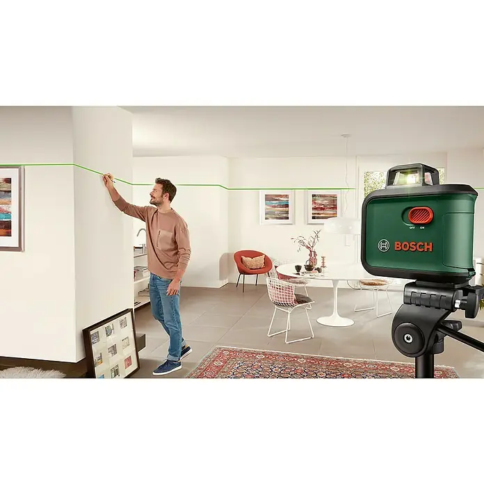 Bosch Kreuzlinienlaser AdvancedLevel 360 - Max. Arbeitsbereich: 12 m, 6 -tlg. - Der Bosch Kreuzlinienlaser projiziert eine grüne Linie an die Wand, während ein Mann diese mit einem Stift nachzeichnet.