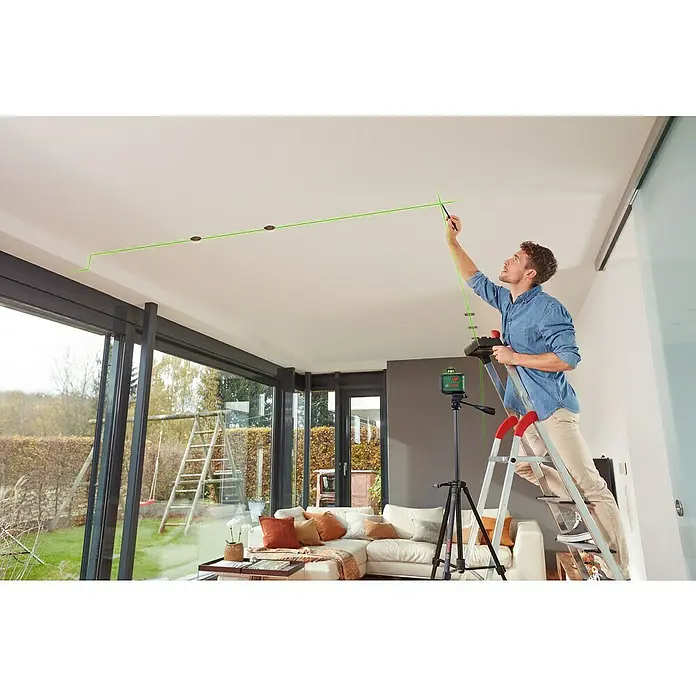 Bosch Kreuzlinienlaser AdvancedLevel 360 - Max. Arbeitsbereich: 12 m, 7 -tlg. - Ein Mann benutzt einen Bosch Kreuzlinienlaser, um eine grüne Linie an einer Zimmerdecke auszurichten, während er auf einer Leiter steht.