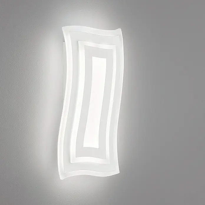 Fischer & Honsel LED-Wandleuchte Gorden - 19 W, L x B x H: 5,5 x 22 x 43 cm, Weiß, Mehrfarbig - Nahaufnahme einer modernen, wellenförmigen LED-Wandleuchte, die an einer grauen Wand befestigt ist und ein warmes, einladendes Licht ausstrahlt.