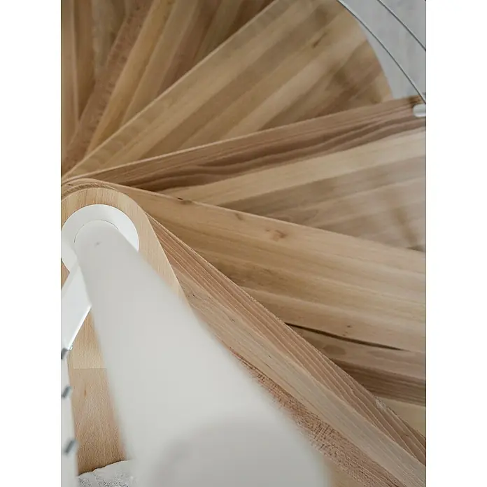 Minka Spindeltreppe Venezia - Durchmesser: 140 cm, Weiß, Farbe Stufen: Buche Natur, Geschosshöhe: 305,5 cm - Detailaufnahme einer eleganten Holzwendeltreppe mit weißem Geländer, die durch ihr stilvolles Design besticht.