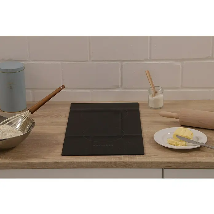 Respekta Kochfeld Bennet - Anzahl Normalkochstellen: 2 Stk. - Eine schwarze Respekta Kochfeldplatte auf einer Küchentheke mit Zutaten wie Butter, Mehl und Zucker für die Zubereitung von Speisen.