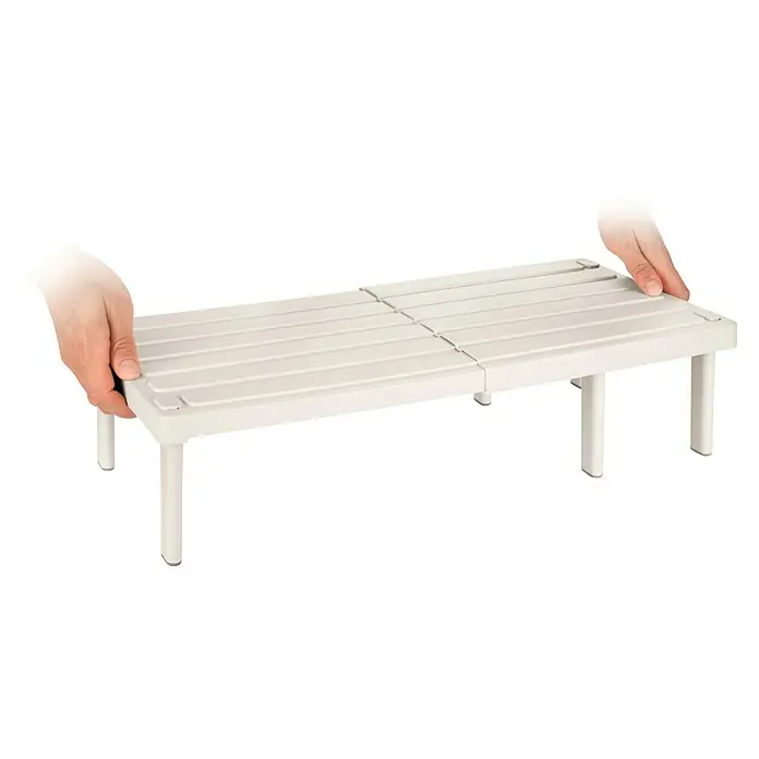 Tescoma Regal Flexi Space - 25 x 42 cm, Beige - Ein verstellbares Küchenregal wird von zwei Händen gehalten, um seine Vielseitigkeit und Anpassungsfähigkeit an verschiedene Schrankgrößen zu zeigen.