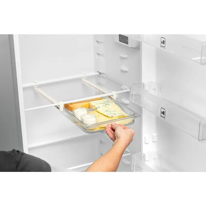 Tescoma Schublade Flexi Space - 24 x 29 cm - Ein Kühlschrank mit einer ausziehbaren Ablage voller Käse, darunter Blauschimmelkäse, Ziegenkäse und Cheddar, die eine köstliche Auswahl bieten.