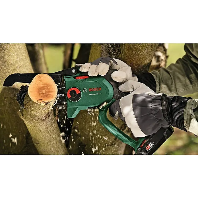 Bosch Power for All 18V Akku-Kettensäge EasyChain 18V-15-7 - 18 V, Li-Ionen, 1 Akku, Schwertlänge: 15 cm - Ein Mann benutzt eine Bosch EasyChain 18V-15-7 Akku-Kettensäge, um einen Ast im Freien zu schneiden, wobei Späne fliegen.